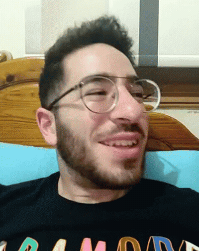 A Man With Glasses And A Beard Is Wearing A Black Shirt That Says Ramone GIF