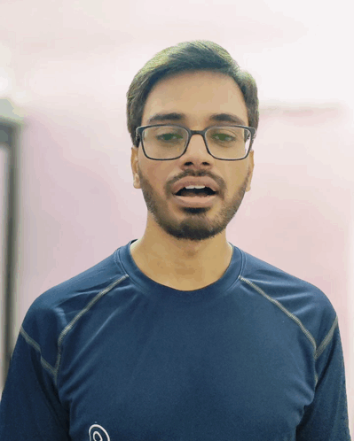 A Man With Glasses And A Beard Is Wearing A Blue Shirt With The Letter C On It GIF