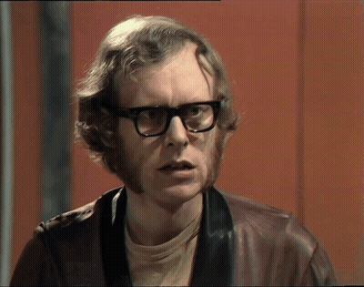 A Man With Glasses And A Beard Is Wearing A Leather Jacket GIF
