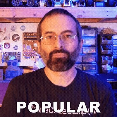 A Man With Glasses And A Beard Is Wearing A Shirt That Says Popular GIF