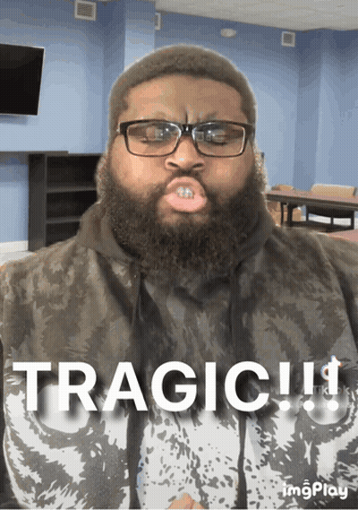 A Man With Glasses And A Beard Is Wearing A Shirt That Says Tragic On It GIF