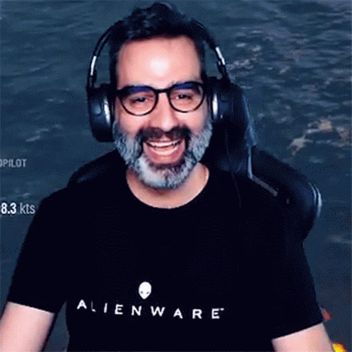 A Man With Glasses And A Beard Is Wearing Headphones And An Alienware Shirt GIF