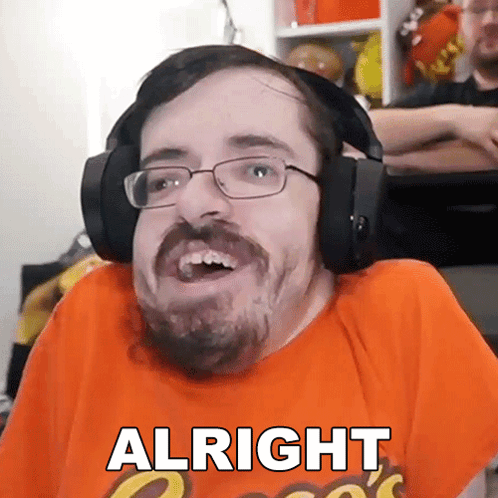 A Man With Glasses And A Beard Is Wearing Headphones And An Orange Shirt That Says Alright GIF