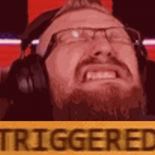 A Man With Glasses And A Beard Is Wearing Headphones And Making A Face . GIF