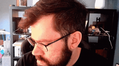 A Man With Glasses And A Beard Looks At The Camera GIF