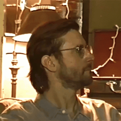 A Man With Glasses And A Beard Looks To His Left GIF