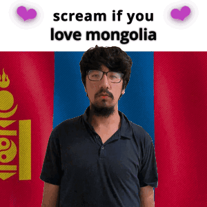 A Man With Glasses And A Beard Stands In Front Of A Mongolia Flag GIF