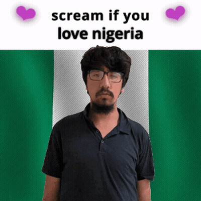 A Man With Glasses And A Beard Stands In Front Of A Nigerian Flag GIF