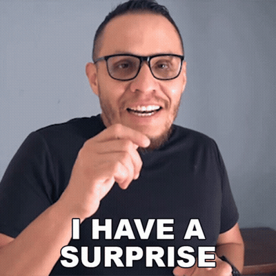 A Man With Glasses And A Black Shirt Says " I Have A Surprise " GIF