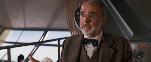 A Man With Glasses And A Bow Tie Is Talking To Someone GIF
