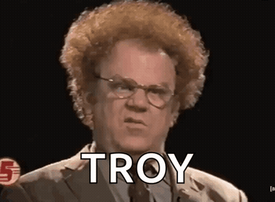 A Man With Glasses And A Curly Haircut Is Talking To Troy . GIF