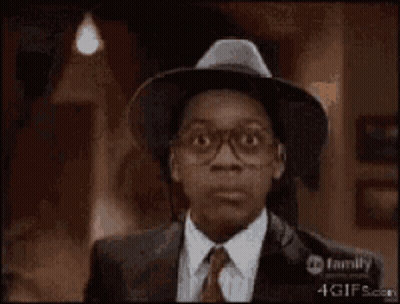 A Man With Glasses And A Hat Is Smiling GIF