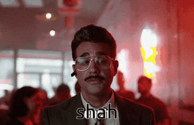 A Man With Glasses And A Mustache Has Shah Written On His Chest GIF