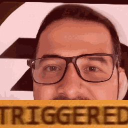 A Man With Glasses And A Mustache Is Holding A Sign That Says Triggered . GIF