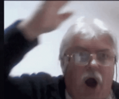 A Man With Glasses And A Mustache Is Making A Funny Face With His Hand In The Air . GIF