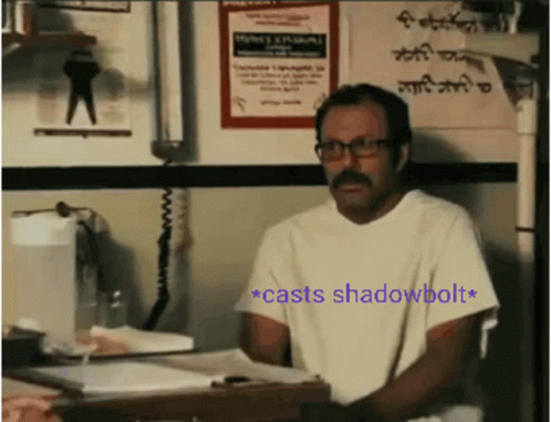 Man With Glasses And Mustache Sitting At Desk With Shadowbolt Sign GIF