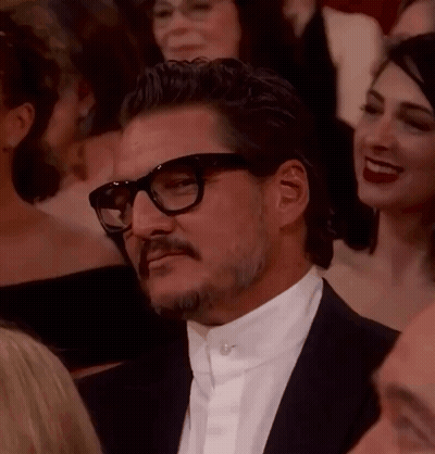 A Man With Glasses And A Mustache Is Sitting In A Crowd Of People . GIF