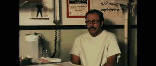 Man With Glasses And Mustache In Front Of Sign 'A GIF