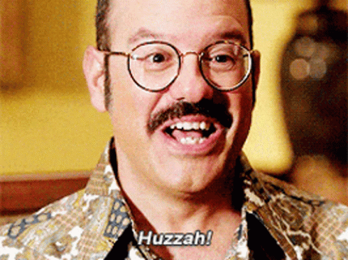 A Man With Glasses And A Mustache Is Smiling And Saying Huzzah GIF
