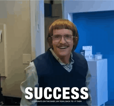 A Man With Glasses And A Mustache Is Standing In Front Of A Sign That Reads Success GIF