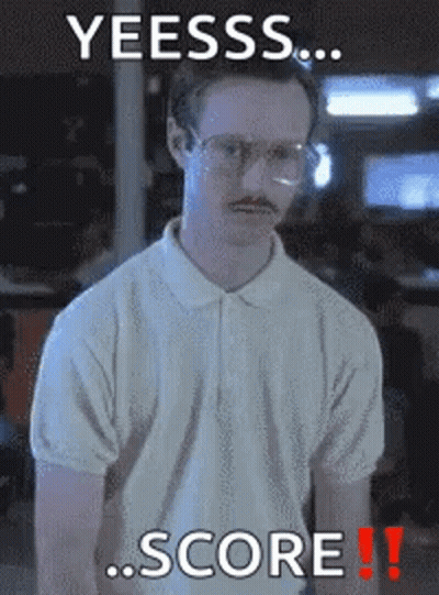 A Man With Glasses And A Mustache Is Standing In Front Of A Sign That Says Yeesss Score GIF