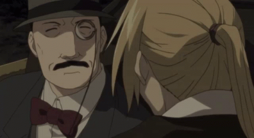 A Man With Glasses And A Mustache Is Talking To A Woman In A Ponytail GIF