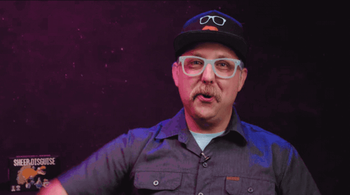 A Man With Glasses And A Mustache Is Wearing A Hat That Says Glasses On It GIF