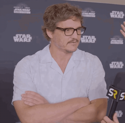 A Man With Glasses And A Mustache Stands In Front Of A Star Wars Sign GIF