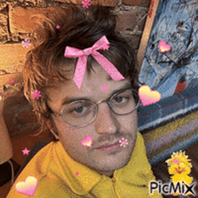 A Man With Glasses And A Pink Bow In His Hair Is Surrounded By Hearts And Stars GIF