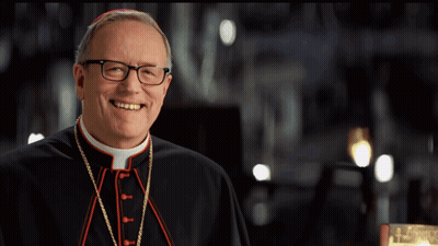 A Man With Glasses And A Purple Hat Smiles For The Camera GIF