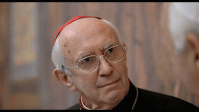 A Man With Glasses And A Red Hat Looks To The Side GIF