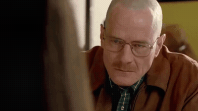 A Man With Glasses And A Shaved Head Is Looking At A Woman . GIF