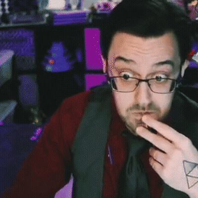 A Man With Glasses And A Tattoo On His Arm Is Pointing At Something . GIF