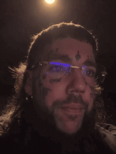 A Man With Glasses And A Tattoo On His Face GIF