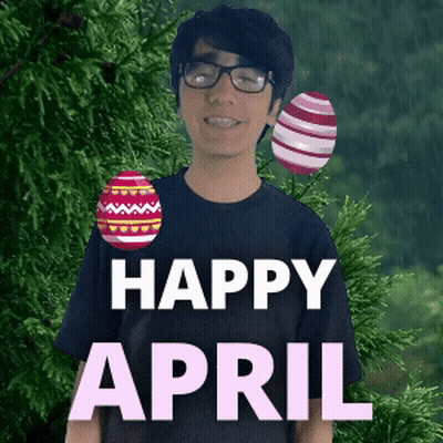 A Man With Glasses And Braces Is Standing In Front Of A Tree With Easter Eggs And The Words Happy April GIF