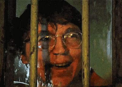 A Man With Glasses Is Behind Bars With His Mouth Open GIF