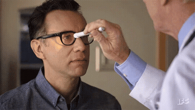 A Man With Glasses Is Being Examined By A Doctor GIF