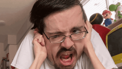 A Man With Glasses Is Covering His Ears With His Hands And Making A Funny Face GIF