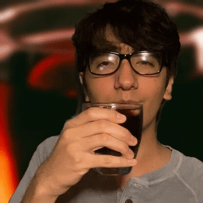 A Man With Glasses Is Drinking A Glass Of Soda GIF