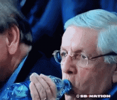 A Man With Glasses Is Drinking From A Plastic Bottle .. GIF