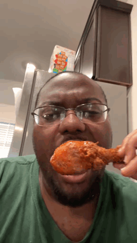 un hombre con gafas está comiendo un trozo de pollo GIF