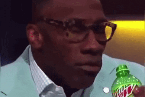 A Man With Glasses Is Holding A Bottle Of Mountain Dew . GIF