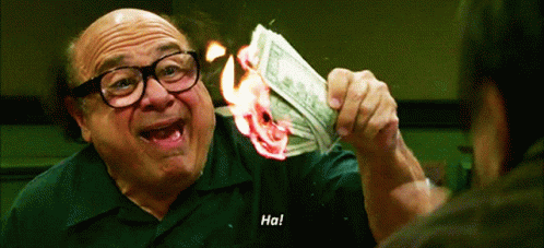 A Man With Glasses Is Holding A Burning Dollar Bill And Says Ha GIF