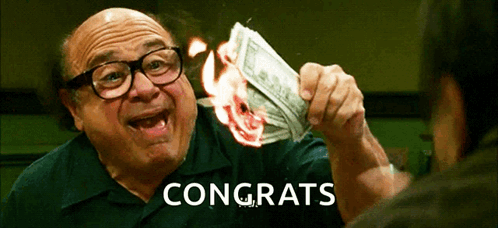A Man With Glasses Is Holding A Burning Dollar Bill And The Word Congrats Is On The Bottom GIF