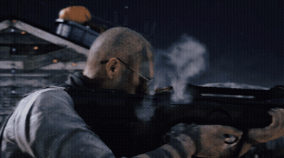 A Man With Glasses Is Holding A Gun And Shooting GIF