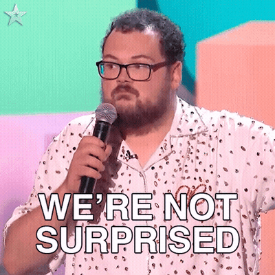 A Man With Glasses Is Holding A Microphone And Saying We 'Re Not Surprised . GIF