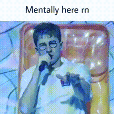A Man With Glasses Is Holding A Microphone And Says Mentally Here Rn . GIF