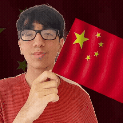 A Man With Glasses Is Holding A Red Flag With Yellow Stars On It GIF