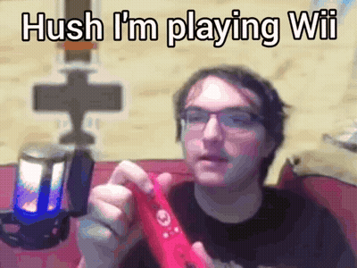 A Man With Glasses Is Holding A Red Wii Controller And Says " Hush I 'M Playing Wii " GIF