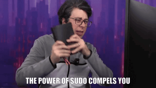 A Man With Glasses Is Holding A Wallet In Front Of A Computer Screen And Says The Power Of Sudo Compels You . GIF